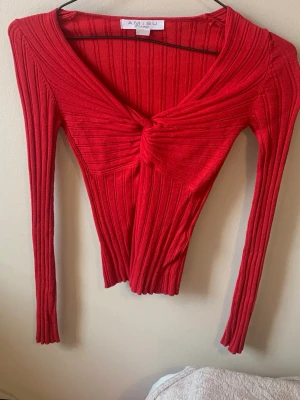 V-ringad top - V-ringad röd top i storlek XS. Sitter tight i stretchigt material. Från AMISU❤️ Använd ett fåtal gånger, inget tecken på användning!