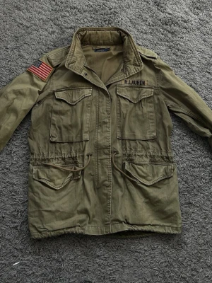 Olivgrön militärrock från Polo Ralph Lauren - Säljer denna schyssta field/militärjackan från Ralph Lauren! Bra skick, och är i en storlek M med lite lösare passform! 