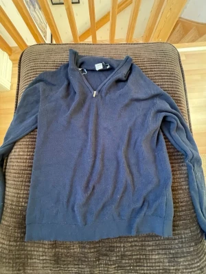 Mörkblå ziptröja från Lindex - Mörkblå långsrmad pinét från Lindex med hög krage och dragkedja framtill. Tröjan har lång ärm och är tillverkad i mjukt material, perfekt för en avslappnad och stilren look.