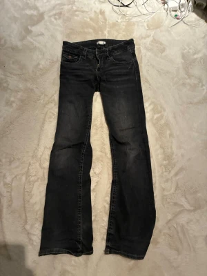 Svarta bootcut jeans Gina Tricot - Svarta bootcut medelmidjade jeans från Gina Tricot. En knapp har gått av och jeansen är lite slitna längst ner. Storlek 164, passar även som xs-s
