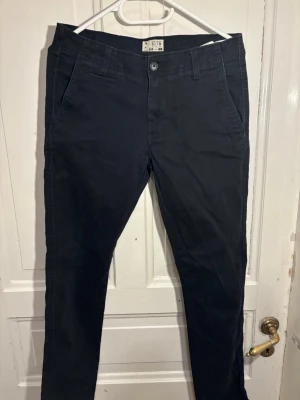 Svarta slim chinos med stretch - Säljes snabbt, är öppen för seriösa bud.      Snygga svarta chinos i slim fit-modell med stretch för extra komfort. Klassisk design med snedställda fickor fram och en bakficka. Perfekta för en stilren och avslappnad look.
