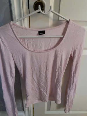 Ljusrosa långärmad topp från Gina Tricot - En enkel och stilren ljusrosa långärmad topp från Gina Tricot. Toppen har rund halsringning och är tillverkad i mjuk bomull, perfekt att matcha med jeans eller kjol. Den har slits vid ärmarna. Finns nån liten suddig fläck någonstans men jag hittar den inte ens. Så nog inget man kommer se. 