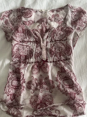 Mönstrad blus med paisley i vinrött - snygg topp med v ringning.