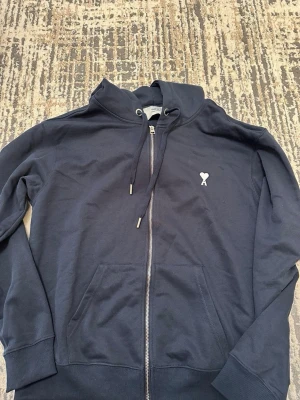 Ami Paris kofta - Snygg mörkblå hoodie från Ami Alexandre Mattiussi med dragkedja, huva med dragsko och två fickor framtill. Priset kan diskuteras vid snabbaffär!!