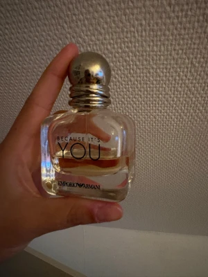 Emporio Armani Because It's You parfym - Emporio Armani Because It's You är en elegant parfym i en genomskinlig glasflaska med rundad form och silverfärgad metallkork. Doften har fruktiga, söta och blommiga toner med inslag av ros, vanilj och citrus. Flaskan har svart text och känns lyxig och modern. Lådan finns ej kvar tyvärr. Förvarat i ett mörkt och svalt ställe. Återstående mängd på bilden kvar. 
