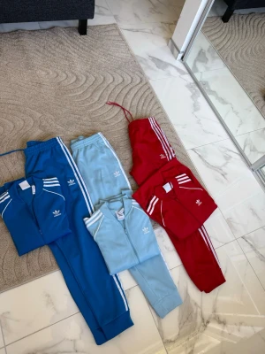 Adidas SST Dressar - Säljer mjukisbyxor från Adidas i tre färger: royal blå, baby blå och röd. Perfekta för en sportig och avslappnad stil. Koftorna är i M och byxorna i L