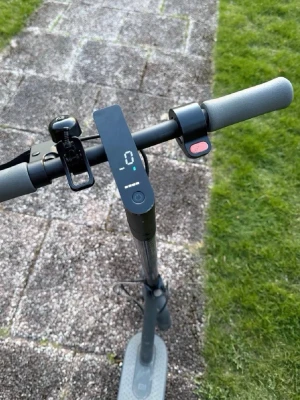 Elscooter Xiaomi Mi svart - Elektrisk scooter från Xiaomi i svart med digital display på styret, grå handtag och fotplatta. Utrustad med ringklocka och tydlig batteriindikator. Perfekt för smidig transport i stan.