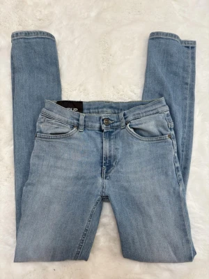 Dondup skinny | 12Y - Säljer ett par ljusblå skinny jeans från Only med klassisk femficksdesign och normal midja. Jeansen har en snygg tvätt och smal passform som sitter tajt längs benen. Perfekta för en trendig och avslappnad stil.