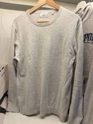 Vit tröja från Bläck - En stilren vit tröja från Bläck i storlek M. Tröjan har rund halsringning och ribbade muddar vid ärmslut och nederkant. Perfekt för en clean och enkel look. 