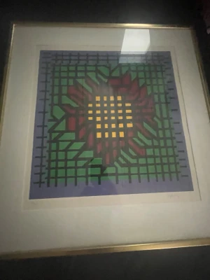 Färgstark grafisk konst i ram - Säljer en inramad grafisk konst med rutmönster i grönt, lila, rött och gult. Motivet är abstrakt och trycket är numrerat 86/250. Verket har en guldfärgad ram och passar perfekt som färgklick på väggen.