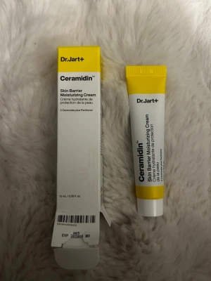 Dr.Jart+ Ceramidin Moisturizing Cream - Dr.Jart+ Ceramidin Skin Barrier Moisturizing Cream i tub, 15 ml. Krämen är vit med gul och vit förpackning, perfekt för att återfukta och stärka hudens barriär. Innehåller 5 ceramider och panthenol för extra vård. Smidig tub som är lätt att ta med. Nypris: 239 (helt oanvänd)