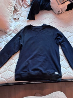 Mörkblå sweatshirt - Mörkblå sweatshirt med rund halsringning och långa ärmar. Tröjan har ribbade muddar vid ärmslut.
