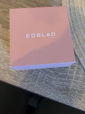 Guldig statementring från Edblad - Säljer en cool och chunky ring från Edblad i guldtonad metall. Ringen har en bred design med flera upphöjda pyramidformade nitar som ger en edgy och modern känsla. Perfekt accessoar för att lyfta din stil. Storlek: S