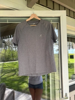 Grå sportig t-shirt från energetics - En stilren grå t-shirt från energetics med korta ärmar och rund hals. Tillverkad i ett mjukt och funktionellt material som passar perfekt för träning eller en aktiv vardag. Diskret logga på bröstet ger en sportig touch.