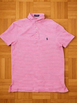 Ralph Lauren Pikétröja  - Ralph Lauren pikétröja Storlek M – nyskick. Rosa/vit randig med klassiska Polo-loggan. Väldigt stilren och perfekt till sommaren. Hör av dig vid intresse/frågor. Först till kvarn! PRIS KAN DISKUTERAS!