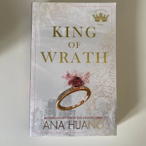 King of Wrath av Ana Huang - En snygg pocketbok med titeln 'King of Wrath' av Ana Huang. Omslaget är vitt med guldiga detaljer, en röd ring och stadssilhuett. Perfekt för dig som gillar romantik och drama.
