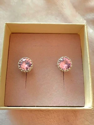 Silvriga örhängen med rosa sten - Snygga örhängen i silverfärg med rund, rosa glittrande sten i mitten. Stenen är infattad i en dekorativ ram med små detaljer runt om. Perfekta för dig som vill ha något som sticker ut lite extra och ger en feminin touch till din stil.