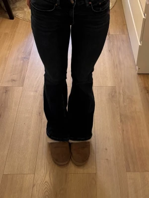 Mörkblå bootcut jeans  - Säljer ett par mörkblå bootcut jeans, med klassisk femficksmodell och medel hög midja. Jeansen har en snygg utsvängd passform nedtill och är tillverkade i ett mjukt denimtyg. 