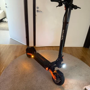 Kukirin g2 pro - Säljer en svart och orange el-scooter av modellen kukirin g2 Pro. Scootern har robust ram, stora hjul, LED-belysning fram och bak samt tydliga detaljer i orange. Perfekt för snabba transporter i stan och har sportig design.