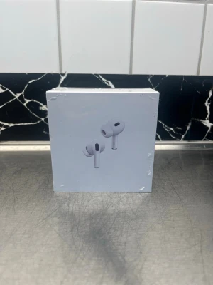 Apple AirPods Pro trådlösa hörlurar - Säljer ett par vita Apple AirPods Pro med laddningsetui. De har en stilren och kompakt design med silikonproppar för bra passform. Perfekta för dig som vill ha grymt ljud och smidig anslutning till din iPhone eller andra Apple-enheter.