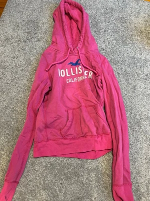 Hoodie från Hollister - Snygg rosa hoodie från Hollister med vit och blå logga. Skriv vid frågor