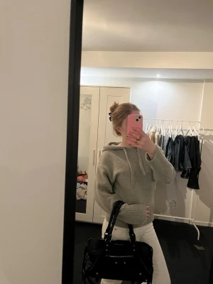 Grå hoodie med huva  - Mysig grå hoodie med huva. Tröjan har en avslappnad passform och ribbade muddar vid ärmslut och nederkant. Perfekt för en chill och stilren look. Inga defekter mer än att den är lite nopprig. Köpt från Vinted 