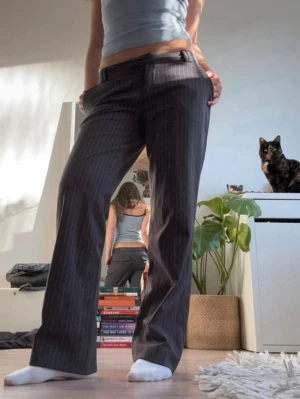 Lågmidjade kostymbyxor - Supersnygga lågmidjade kostymbyxor! Halva ”pluppen” på dragkedjan har ramlat av men man kan fortfarande använda den. Jag har klippt av ”flikarna” över fickorna så de ser mer ut som klassiska kostymbyxor ❤️