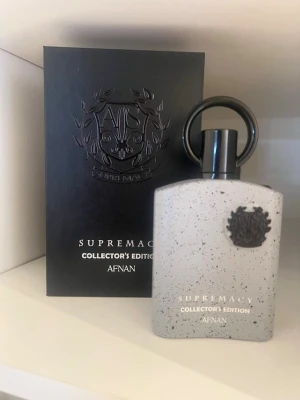 Afnan Supremacy Collector's Edition parfym - Supremacy Collector's Edition parfym från Afnan i en snygg gråspräcklig flaska med svart lock och emblem. Doften har noter av ananas, bergamott, äpple, vit blomma, apelsinblom, björk, amber, ekmossa, mysk och ambra. Kommer i exklusiv svart förpackning.