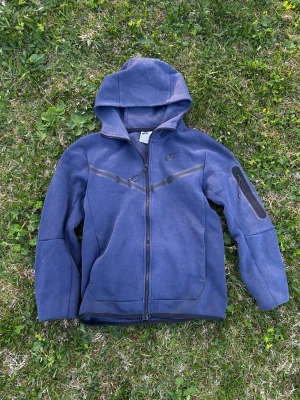 Nike tech tröja - Säljer en blå nike tech tröja. Den är ganska använd, den har defekter och är sönderblekt på vissa ställen. Den är xs men jag upplever den som en S. Pris ej hugget i sten, kom privat vid intresse. 