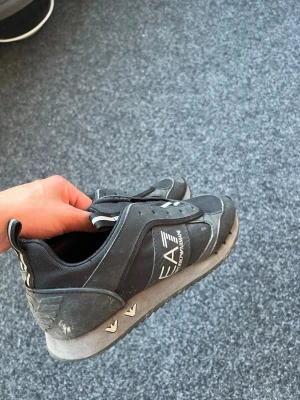 Svarta EA7 sneakers från Armani - Knappt använda smutsade bara ner de i vintras ja vinter det var sista gången jag använde dom jag köpte de för 2100 från boozt och använde dom i 1 månad knappt för dom var för små. Enda problemet var att jag tog bort shoe laces så de har inga shoe laces för att dom var för små så jag rocka dom utan shoe lace sen tappa bort shoe laces.