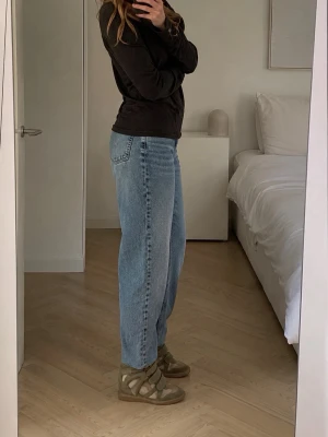 Isabel Marant höga sneakers i mocka - Säljer ett par ikoniska höga sneakers från Isabel Marant i olivgrön mocka och beige läderdetaljer. Skorna har flera kardborreband och en chunky sula som ger en cool siluett. Perfekta för dig som vill ha en statement sneaker med streetstyle-vibe.