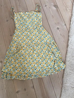 Blommig gul sommarklänning med snörning - Söt blommig klänning med gula och vita blommor på ljus botten. Klänningen har smala axelband, snörning i ryggen och en lätt utställd kjol. Perfekt för soliga dagar och ger en fräsch och ungdomlig look. Klänning från Urban outfitters💓