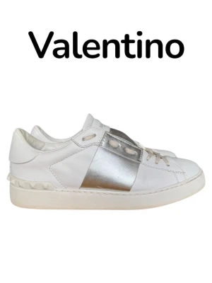 Valentino opens 39 - Snygga vita sneakers från Valentino med en bred metallic silverdetalj över mitten. Skorna har klassisk låg profil, vita snören och nitar längs hälen. Tillverkade i slätt läder för en lyxig känsla och modern look. Väldigt fint skick 8,5/10, skorna är i storlek 39.