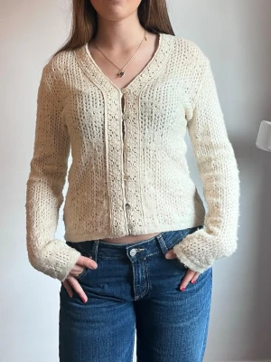 Söt kofta Zara - Säljer denna söta beiga/cremevita koftan från Zara med blomdetaljer i storlek M. Koftan är aldrig använd.