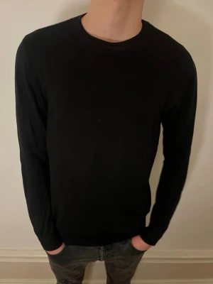 Svart stickad tröja. - Säljer min oanvända sweatshirt från dressman. Jag på bilden är 182 och väger 70kg.  Hör av dig vid frågor och funderingar!