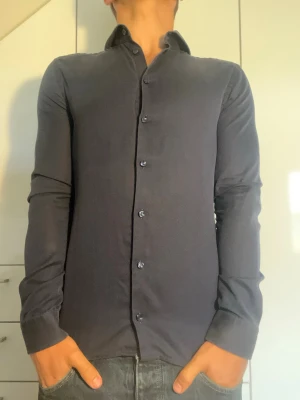 Mörkblå skjorta från Eton - Mörkblå skjorta från Eton i 100% bomull. Strl S. Inga defekter. Modellen är 178 cm och väger 77 kg. Hör gärna av dig vid frågor!