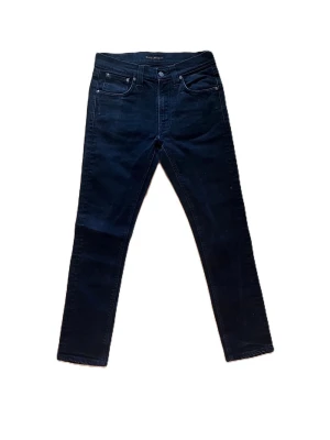Svarta slim fit jeans från Nudie Jeans - Snygga svarta slim fit jeans från Nudie Jeans med klassisk femficksmodell och hög midja. Jeansen är W29 L30, men sitter mer som w28, dom har design på bakfickan, om du har några funderingar är det bara att skriva. Priset är ej hugget i sten.