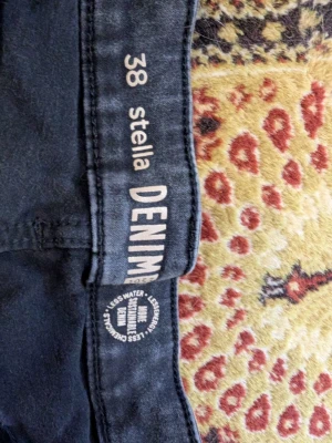 Svarta medium tighta jeans Stella Denim - Säljer ett par svarta jeans mellan tighta från Stella Denim. De har klassisk femficksdesign, hög midja och smal passform hela vägen ner. Materialet är stretchigt för extra komfort och sitter snyggt på benen. Perfekta för en trendig och avslappnad look.