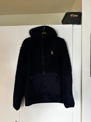 Marinblå fleecehoodie Polo Ralph Lauren - Säljer en marinblå hoodie från Polo Ralph Lauren i mjuk teddyfleece i gott skick. 