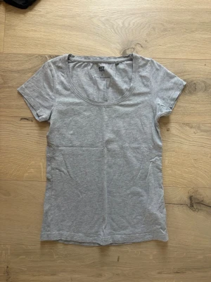 Grå basic t-shirt från 157 Xs - En enkel och stilren grå t-shirt från 157 med rund halsringning och korta ärmar. Tillverkad i mjuk bomullsblandning som ger en skön och stretchig passform. Perfekt till alla dina outfits.