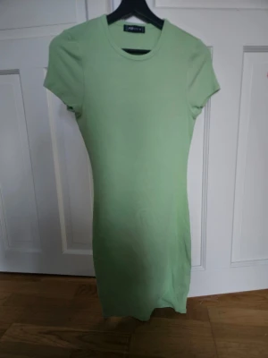 Ljusgrön ribbad klänning FB Sister - Säljer en ljusgrön ribbad kortklänning från FB Sister. Klänningen har en enkel och slim passform med rund halsringning och korta ärmar. Perfekt för dig som gillar en clean och stilren look. Materialet är mjukt och stretchigt, vilket gör den bekväm att bära.