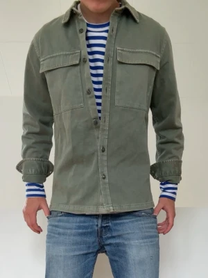 Olivgrön Overshirt  - Olivgrön Overshirt i strl M men sitter som en S! Bra skick utan nåra defekter och hör gärna av er vid frågor elr funderingar!!