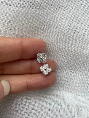 Blommiga silvriga örhängen, vitguld pläterade, topp kvalitet - Säljer ett par silvriga örhängen i form av små blommor med pärldetaljer runt kanterna. De har en elegant och tidlös design som verkligen poppar. Perfekta för dig som gillar stilrena accessoarer med det lilla extra.