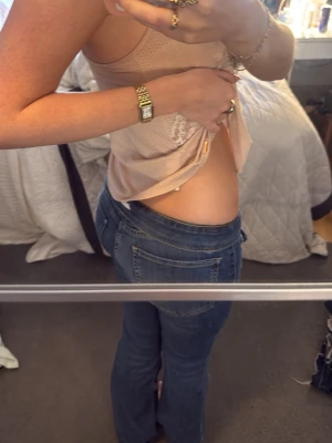 Blå bootcut jeans med fickor fram - Säljer ett par blå bootcut jeans med markerade sömmar och stora fickor fram. Jeansen har låg midja och klassisk femficksdesign. Perfekta för dig som gillar en avslappnad men ändå trendig look.