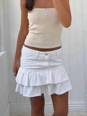 Vit volangkjol med jeansdetaljer - Supersöt vit kortkjol med volanger och jeansdetaljer. Kjolen har två lager volang, råa kanter och klassisk knapp- och dragkedjestängning framtill. Perfekt för dig som vill ha en trendig och avslappnad look i sommar. Har används ungefär 3 gånger och är som ny! 