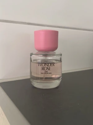 Zara Wonder Rose parfym - Fräsch parfym från Zara, Wonder Rose, med en söt och blommig doft. Flaskan är rund och genomskinlig med ljusrosa vätska och ett stort rosa lock. Perfekt för dig som gillar feminina och fräscha dofter.