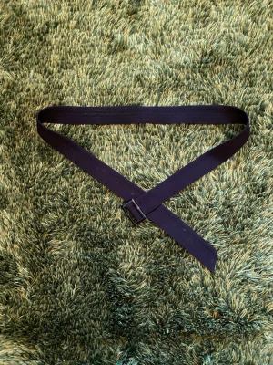 Svart tygskärp med fyrkantigt spänne - Säljer ett svart bälte i tyg med ett stilrent fyrkantigt spänne. Perfekt för att ge en enkel och clean look till outfiten. Bältet är lite bredare och flexibelt, vilket gör det lätt att justera helt efter behov.