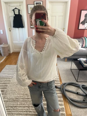 Vit blus med ballongärmar - Vit tunn blus från scotch & soda med jättefina nitdetaljer runt halsen och broderie detaljer på ärmarna⭐️ Påminner lite om isabel marant med en bohemisk stil. Helt ny med lappen kvae, aldrig använd! Står att det är storlek xs men passar även s och m då den är lite oversized. 