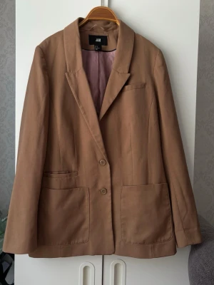 Brun kavaj  - Ljusbrun kavaj från H&M i strl 40 med framfickor och knappar! Skulle säga mer strl 38 till passformen❤️