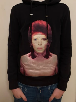 Svart t-shirt med tryck från Limitato - Cool svart hoodie från Limitato med ett stort färgstarkt tryck på framsidan. T-shirten har korta ärmar och en klassisk passform som är perfekt för att sticka ut. Materialet känns mjukt och bekvämt, troligen bomull. Storlek XS men passar även på S.